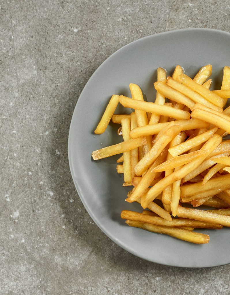 Plato gris con patatas fritas doradas.