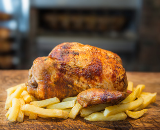 Pollo asado entero sobre una tabla de madera, listo para servir.